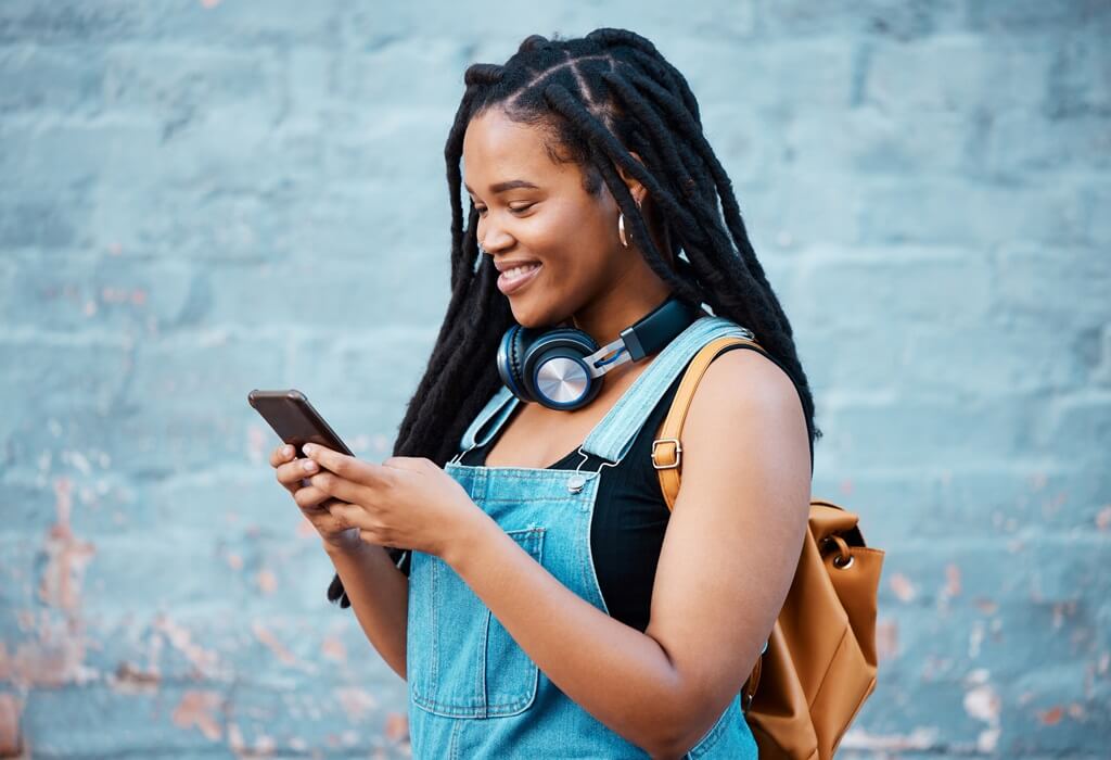 moça sorridente digitando no celular